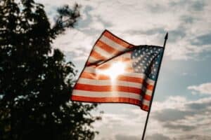 american flag under a cloudy sky