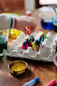 person holding easter egg on palette tray