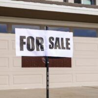 for sale sign in front of a house